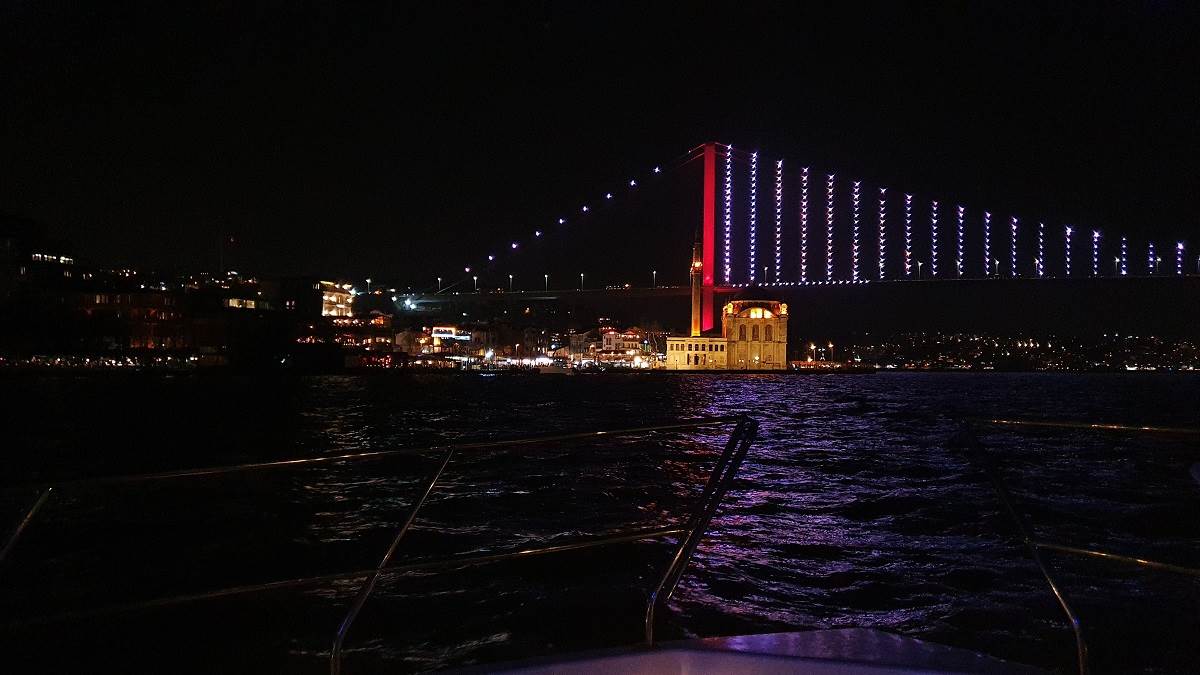 A night view of the Istanbul Bosphorus and the lights of Ortaköy Mosque taken from the bow of a luxury yacht