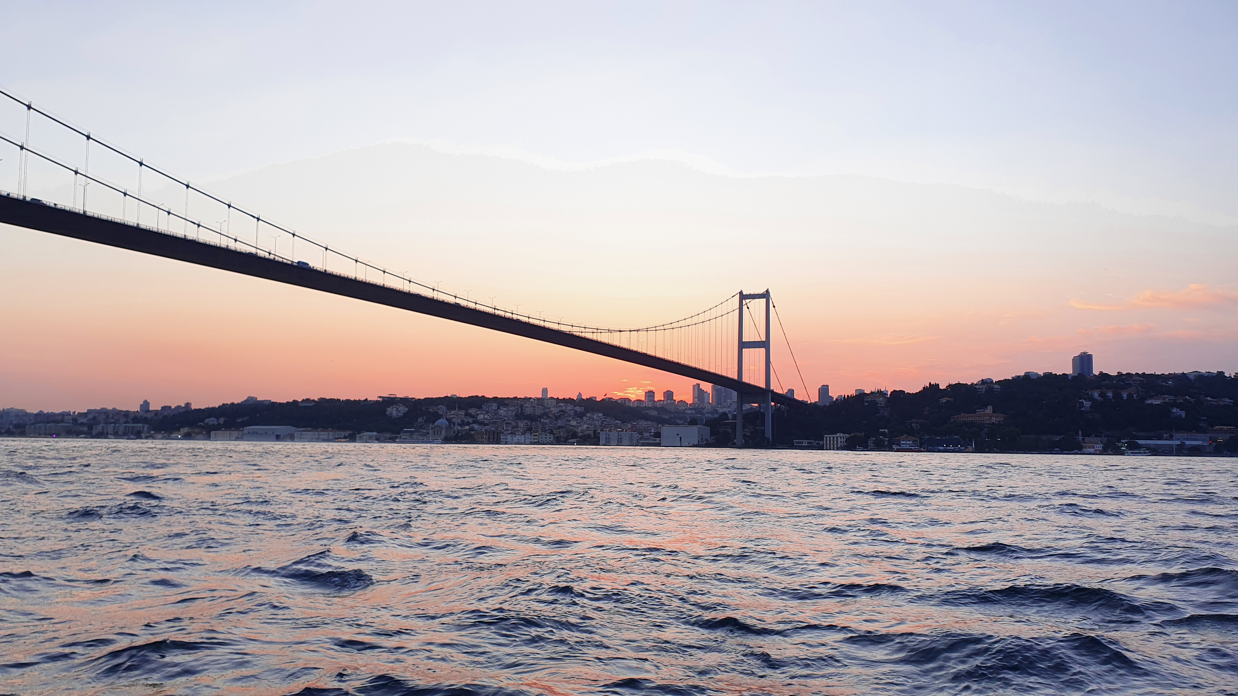 Le pont du Bosphore et ses rives sous un ciel rose en soirée